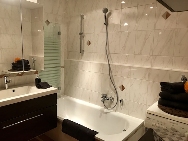 Badewanne, Haartrockner, Hausschuhe, Handtücher