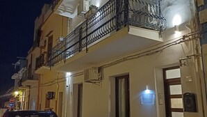 A residential building with a balcony, a parked car, and a motorcycle. - Terra Sinus B&B Unique and wonderful location (Terrasini)