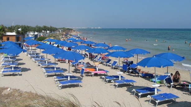 A beach with rows of blue umbrellas and sun loungers. - Terra Sinus B&B Unique and wonderful location (Terrasini)