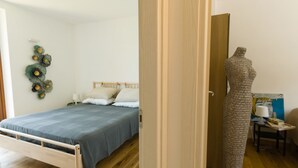 A bedroom with a bed, a wall-mounted decoration, and a mannequin.