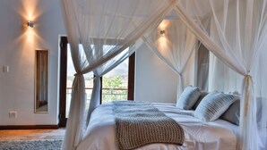 A bedroom with a bed, canopy, and two wall-mounted lights. - Xairu at Le Domaine Eco-Reserve (Country living) (Montagu)