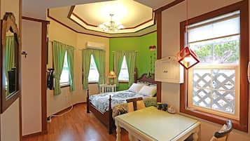 A bedroom with a bed, a table, and a window with a view.