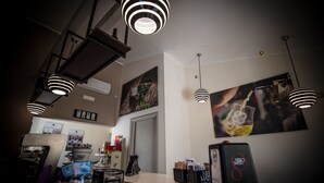 Eine moderne Küche mit Pendelleuchten, einer Kaffeemaschine und einem Kühlschrank.