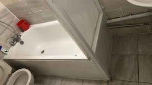 Casa de banho com banheira, sanita e lavatório.