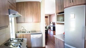 A compact kitchen with wooden cabinets, a built-in dishwasher, a gas stove, and a refrigerator. - La Bri Self Catering (Clarens)