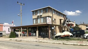 A two-story building with a covered entrance and a sign indicating it is an EV Hotel. - Ev Otel (Çanakkale)