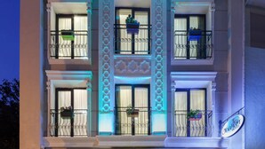 Un hotel de varios pisos con balcones, ventanas amplias y un cartel que indica que es un hotel.
