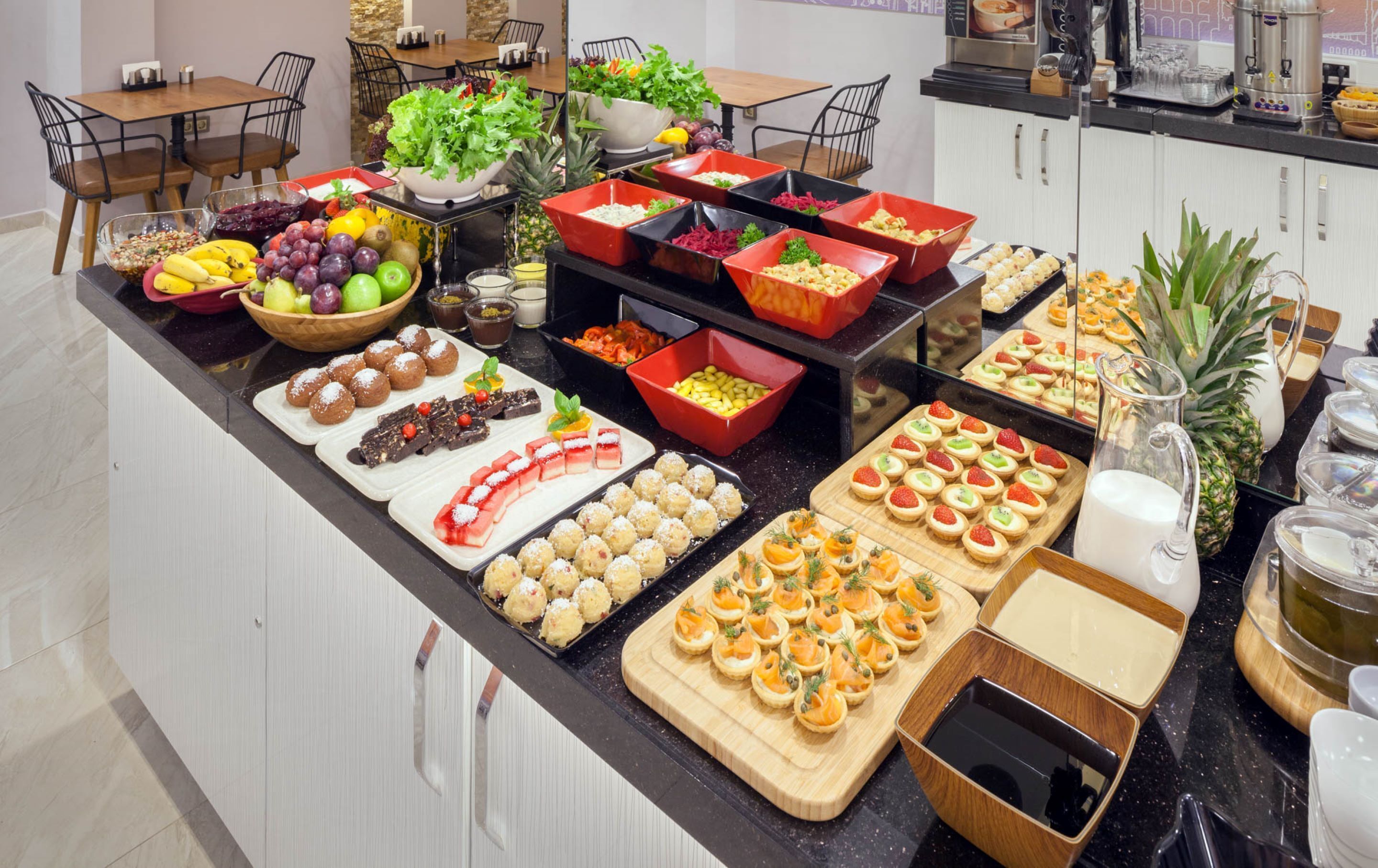 A buffet with various food items and a coffee station.