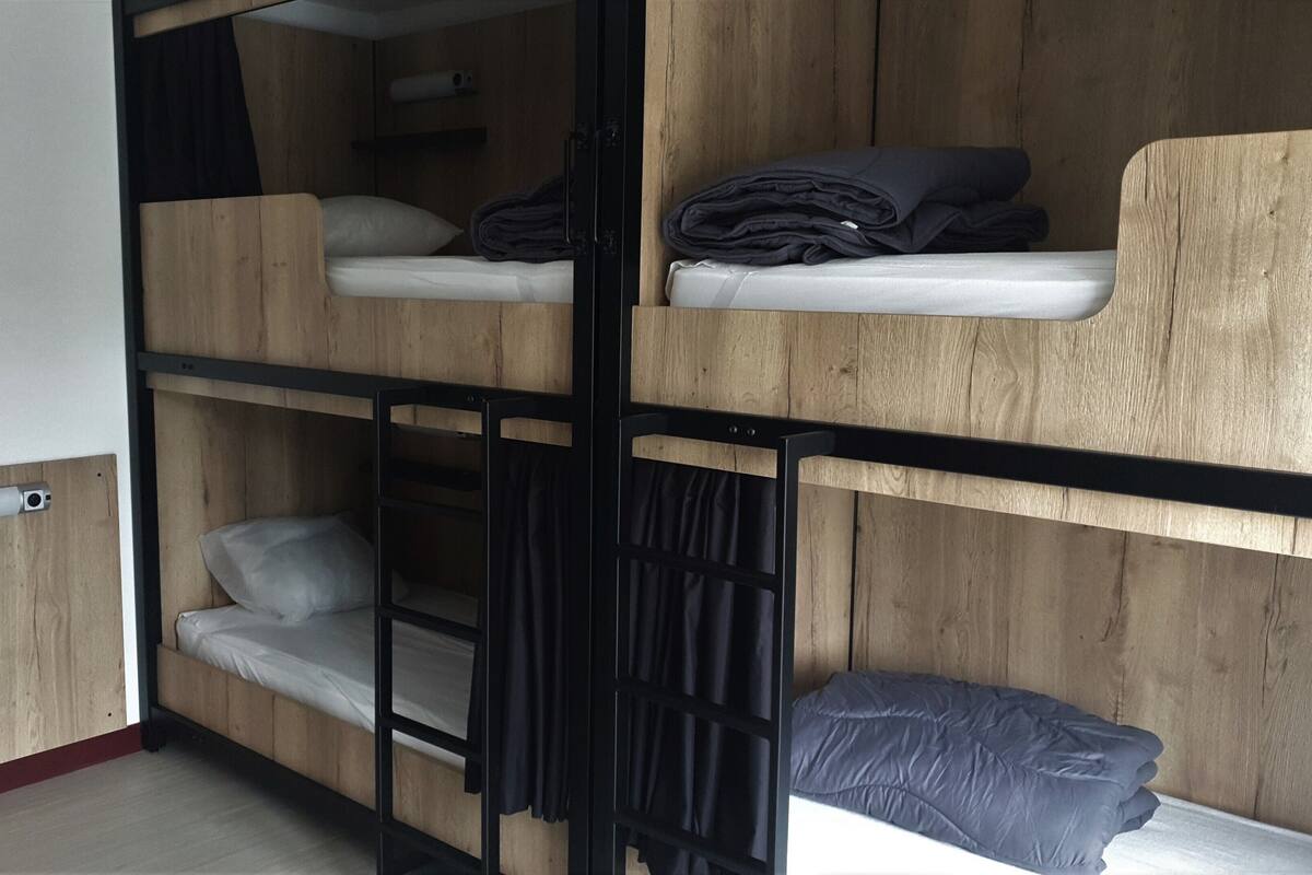 A bunk bed room with wooden walls and a white door.