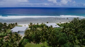 A coastal property with two buildings, a beach, and palm trees. - Coast Cook Islands - 3-Bedroom Beachfront Pool Villa (Rarotonga)