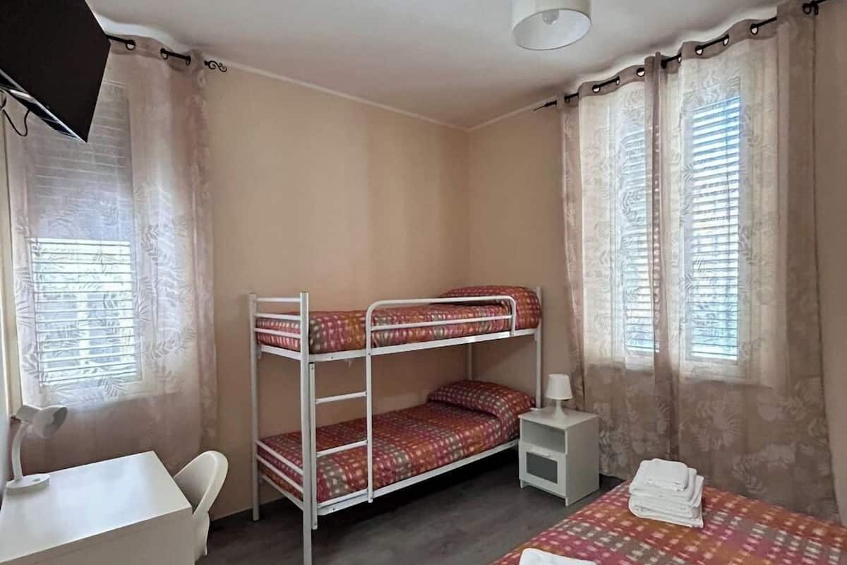 Habitación cuádruple básica | Edredones de plumas, minibar, mobiliario individual y escritorio