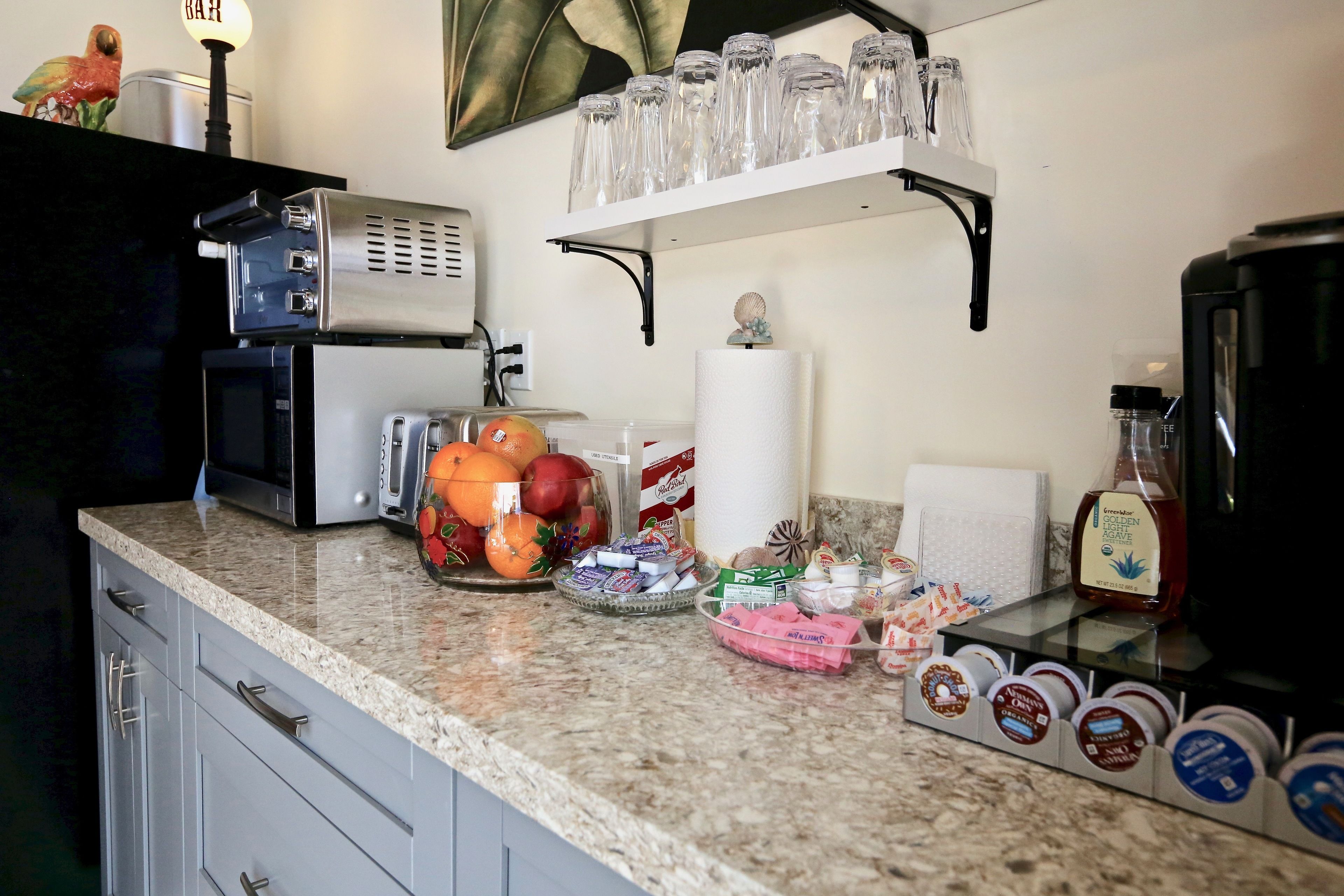 A kitchen counter with a coffee maker, toaster, and various food items.