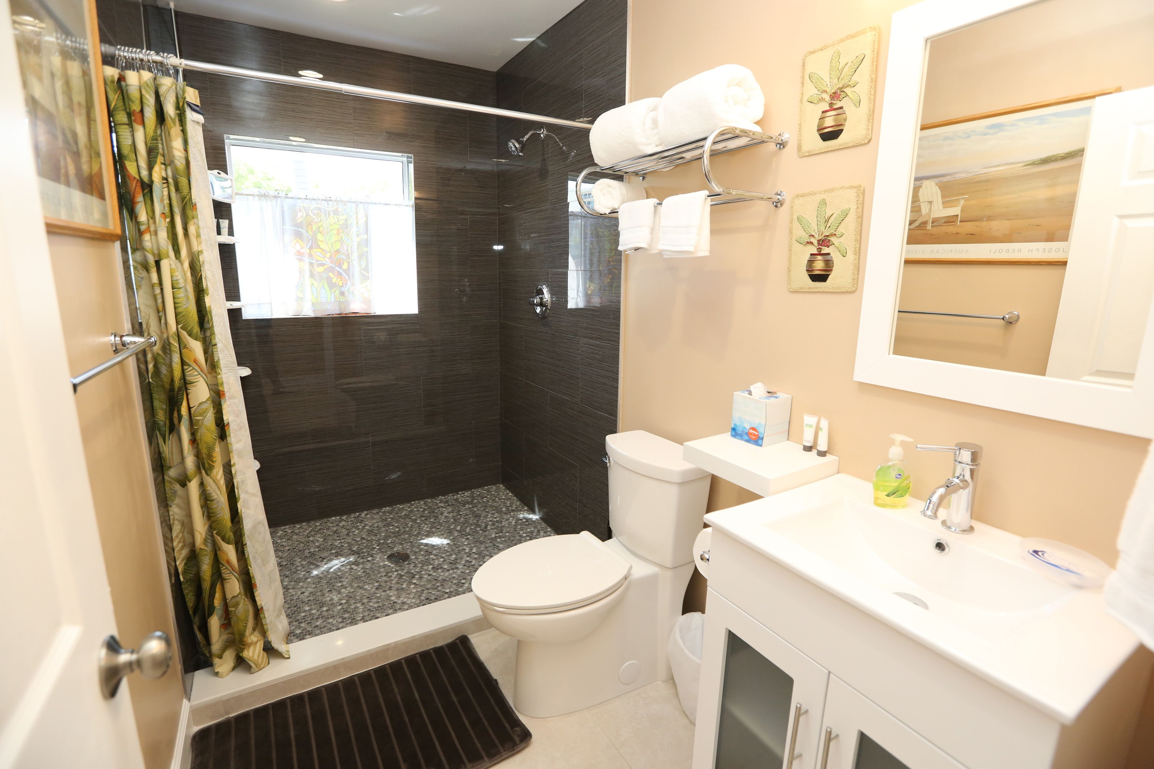 A modern bathroom with a shower, toilet, and sink.