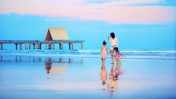 A beach scene with a pier in the background.