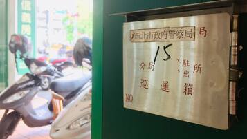 A metal sign with Chinese characters and a number '15' on it, mounted on a green wall.