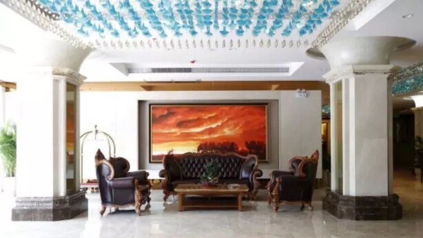 A lobby with a large painting, a sofa, and a coffee table. - Zhuhai Asian Star Hotel (Zhuhai)