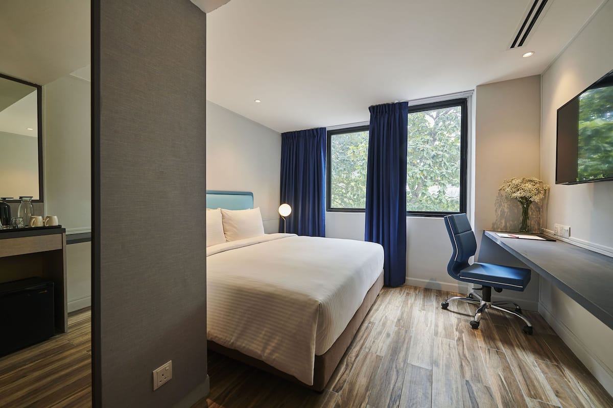 Ein modernes Hotelzimmer mit einem großen Bett, einem Schreibtisch und einem Stuhl.
