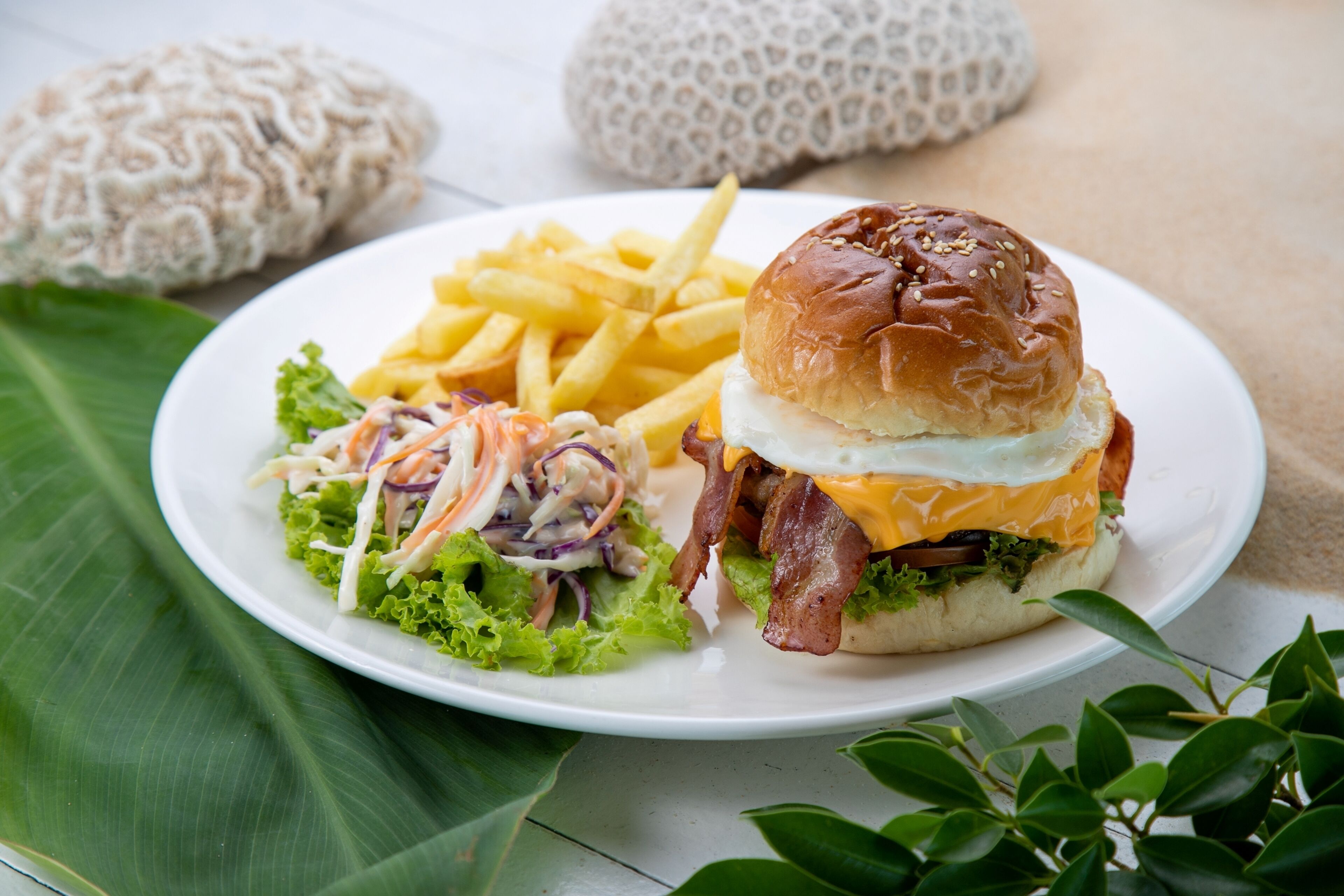 A plate with a burger, fries, and coleslaw.