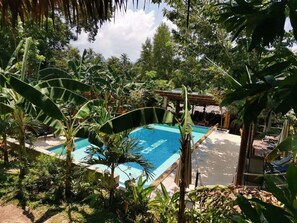 Una piscina al aire libre, una piscina infinita, sombrillas