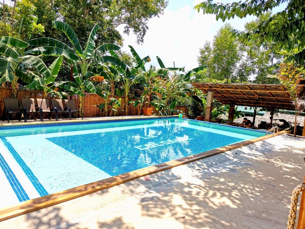 Outdoor pool, an infinity pool, pool umbrellas, pool loungers