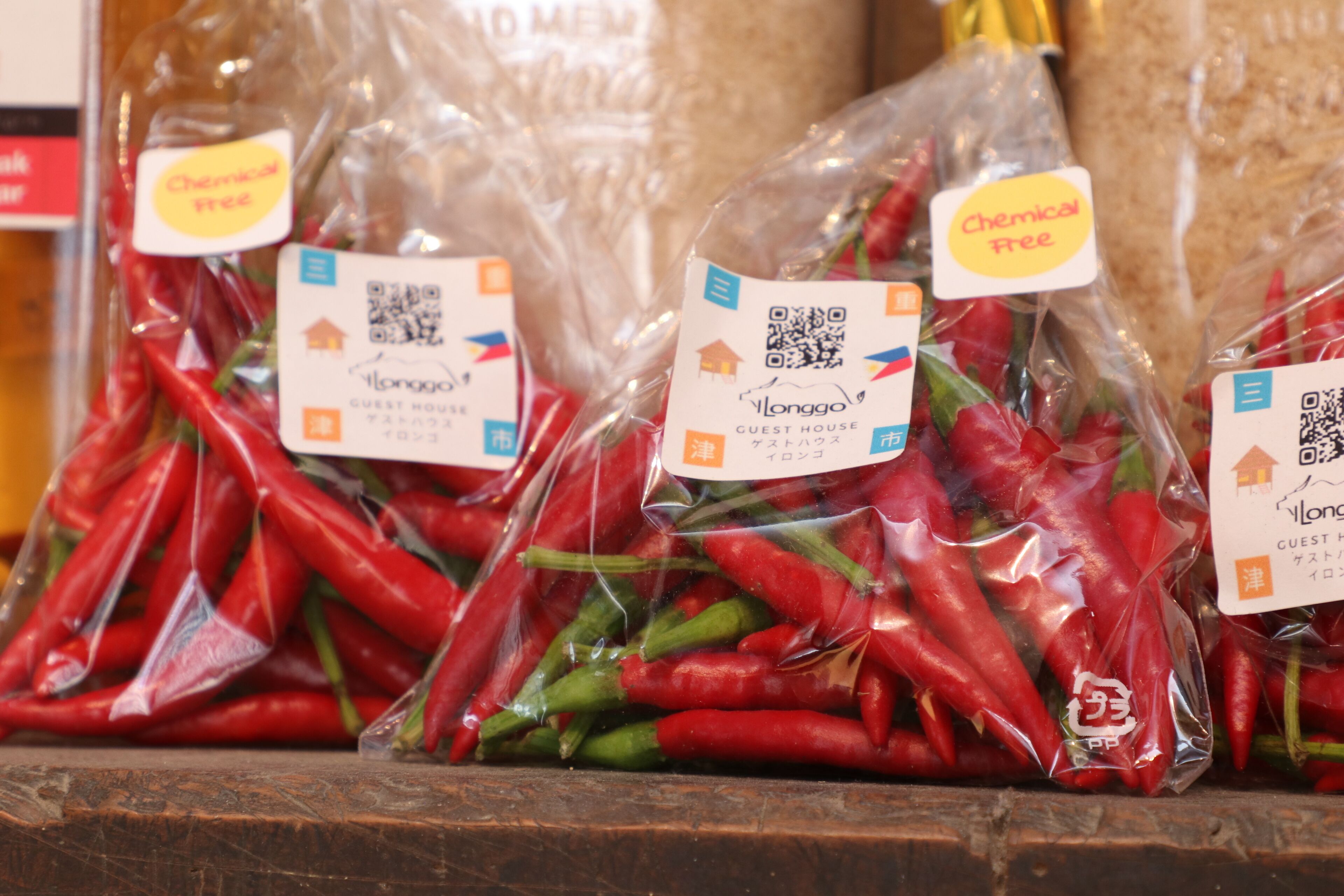 Sacchi di peperoncino rosso con l'etichetta 'Chemical Free' e 'Longgo Guest House'.