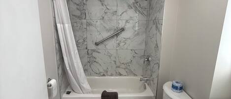 A bathroom with a bathtub, toilet, and vanity.