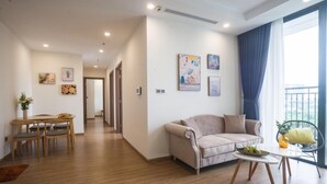 Een moderne woonkamer met een bank, een eettafel met stoelen en kunstwerken aan de muur.