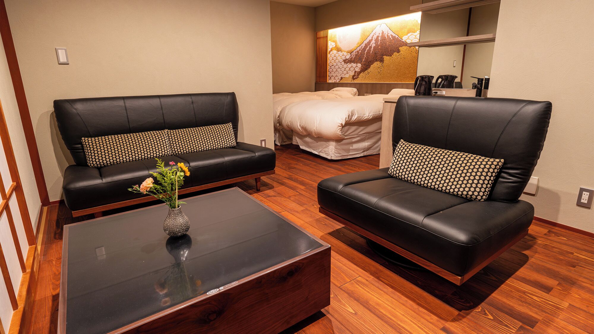 Een hotelkamer met een bank, een stoel, een bed en een salontafel.