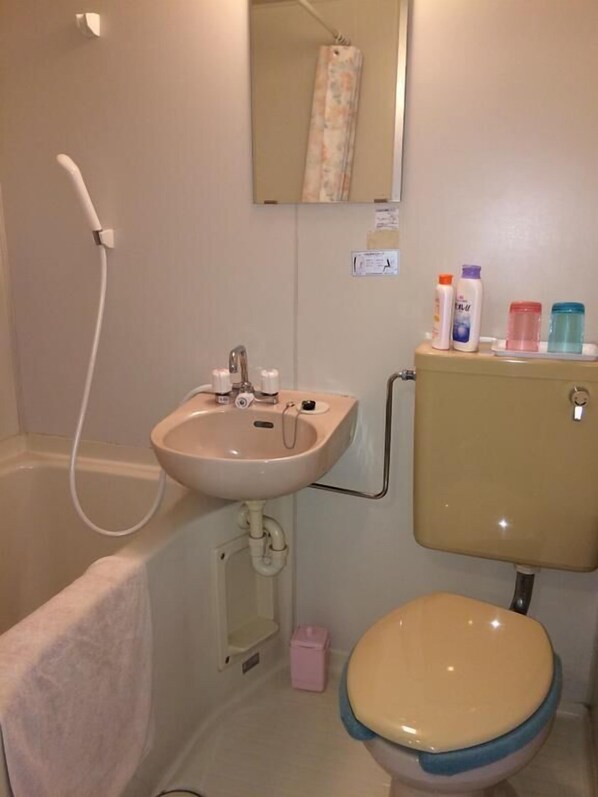 Un baño con lavamanos, inodoro y ducha.