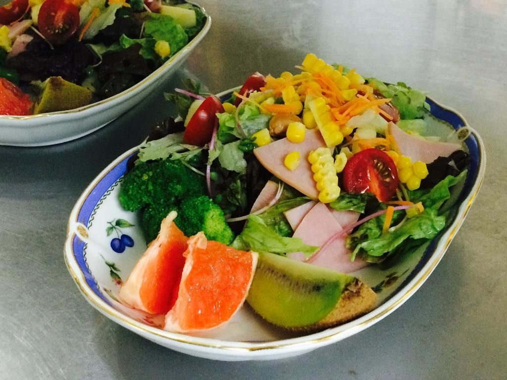 A bowl of salad with various vegetables and fruits.