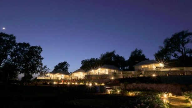 A large, multi-story building with multiple illuminated windows and a well-lit exterior. - Charekh Food & Forest Resort (Lansdowne)