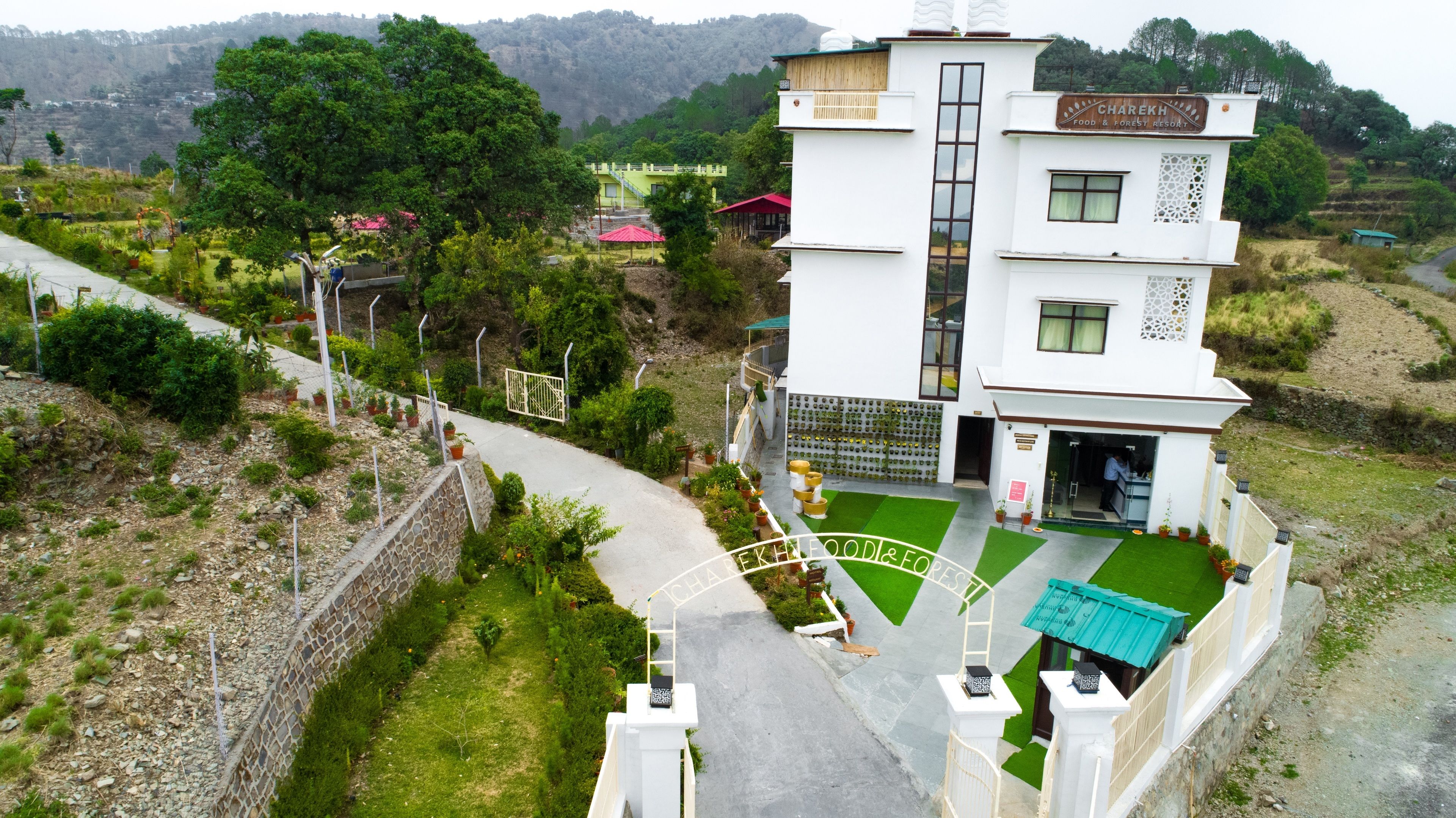 A multi-story building with a sign reading "Charek Resort Food & Forest Resort".