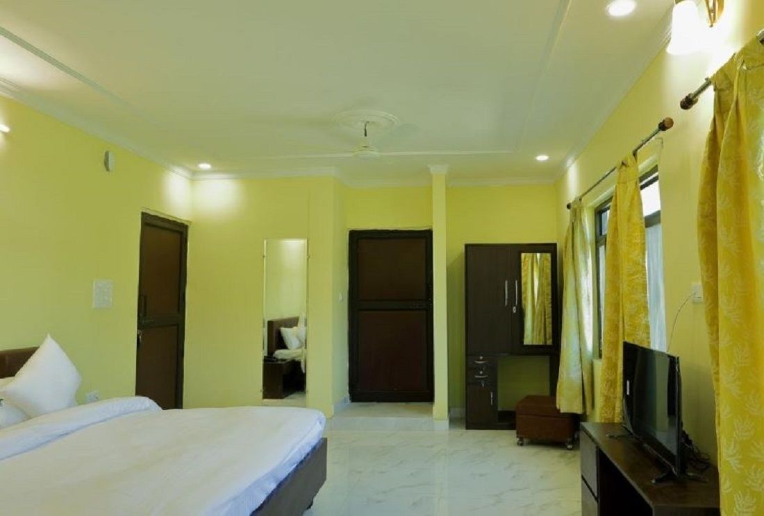 Habitación de hotel con cama, televisor, armario y escritorio.