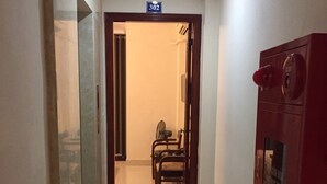 Un corridoio con un estintore, una porta contrassegnata dal numero 302 e una sedia in lontananza.
