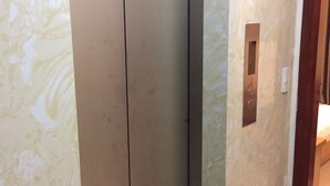 Un corridoio con una porta che dà sull'ascensore.
