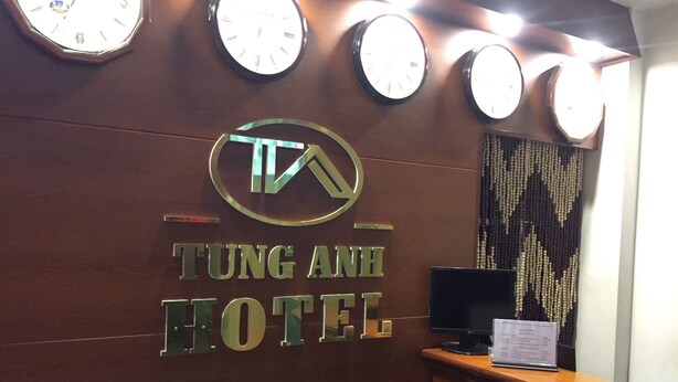 Una reception con una insegna che recita 'TUNG ANH HOTEL' e diverse pendole sopra.