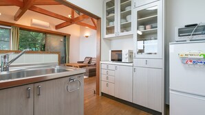 Una cocina moderna con vigas de madera, microondas integrado y refrigerador.
