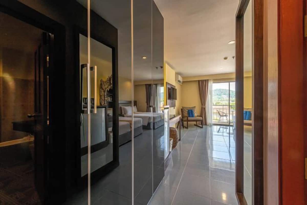 A modern hotel room with a large bed, a seating area, and a view of the outdoors.