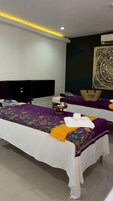 Camera d'albergo moderna con un letto grande, un comodino, un pannello decorativo e una luce a soffitto.