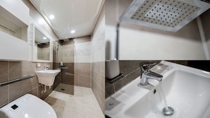 A modern bathroom with a shower, sink, and toilet.