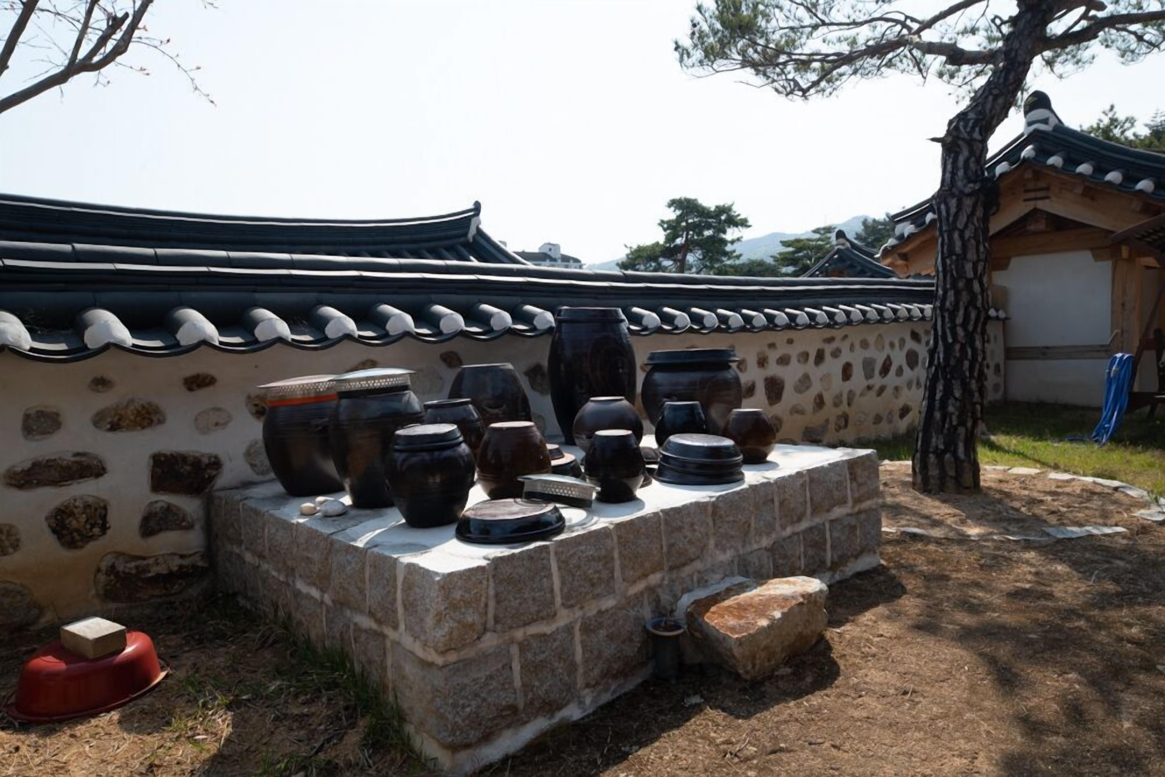 Ein traditionelles koreanisches Gebäude mit einem Ziegeldach und einer Steinwand.