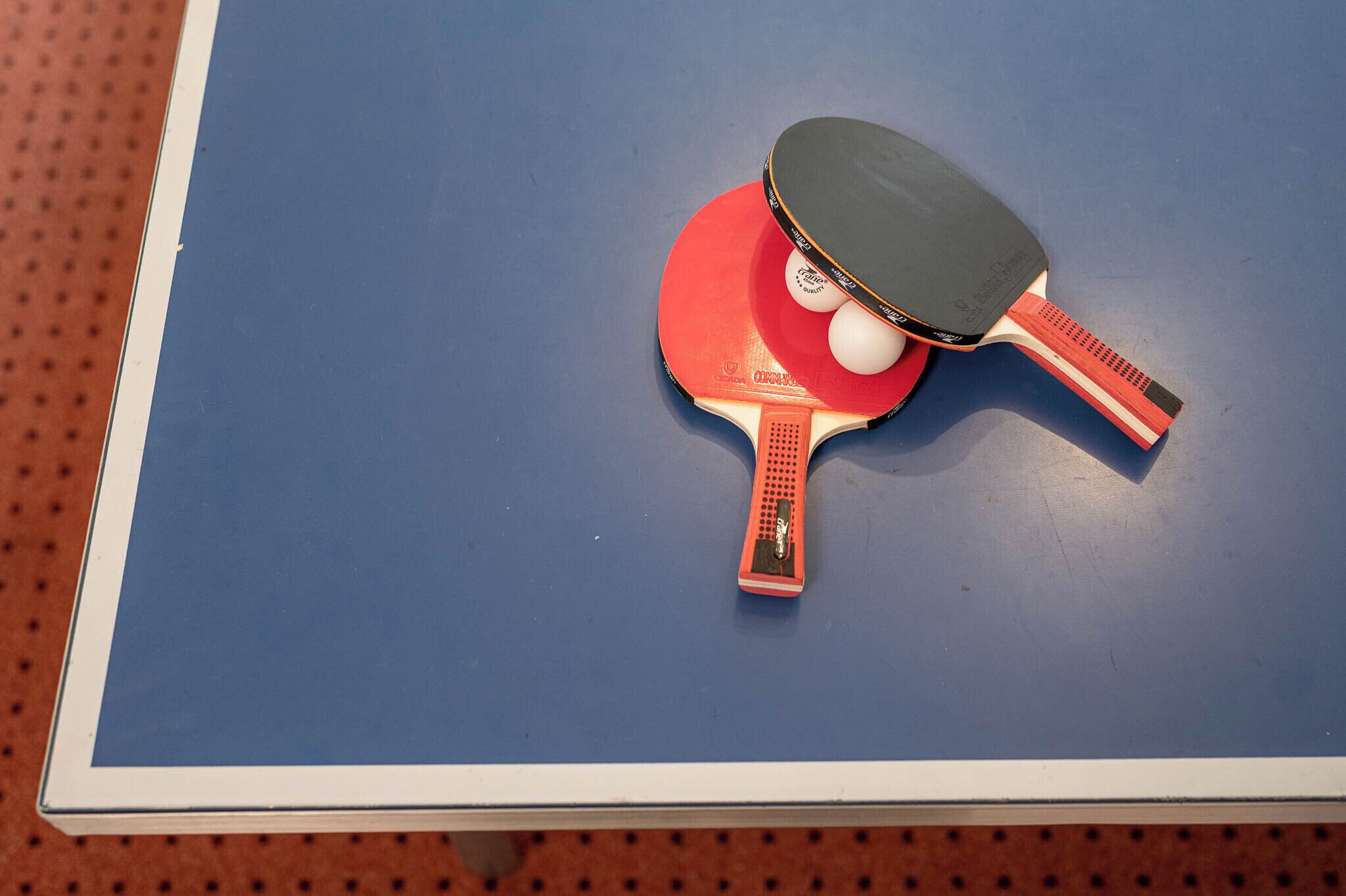 Ein Tischtennistisch mit zwei Schlägern und einem Ball.