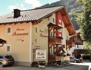Un edificio con un letrero que dice 'Pension Posauner' y 'FAM. ETZER ZIMMER'.