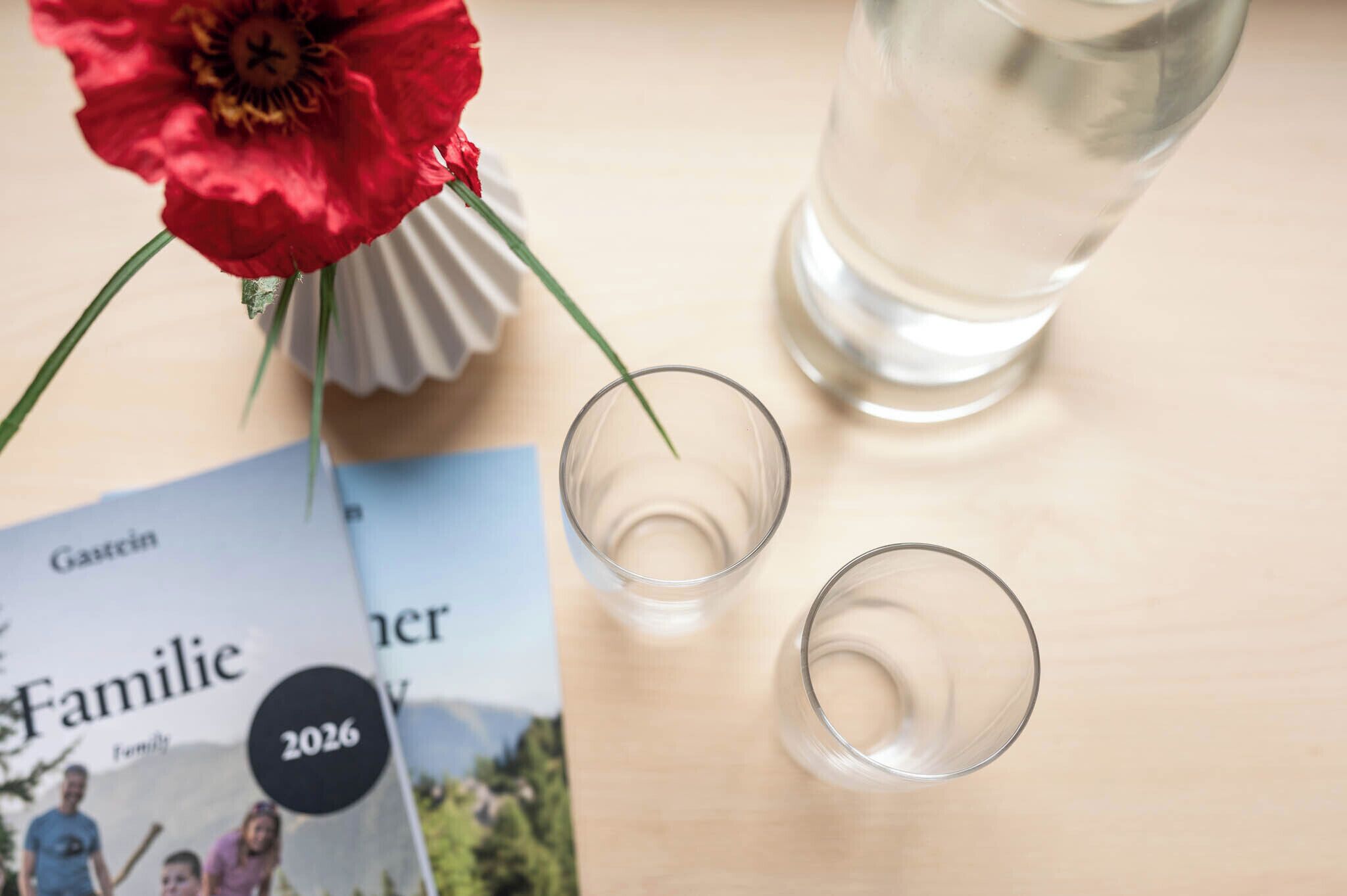 A magazine titled 'Familie' with a visible year '2026' and a glass of water on a table.