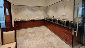 Una cocina moderna con salpicadero de mármol, armarios de madera oscura y una puerta de cristal con un letrero que dice 'G'.
