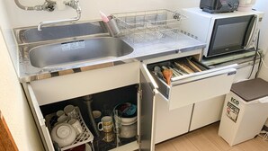 Une cuisine de taille réduite équipée d’un évier, d’un four à micro-ondes et d’un lave-vaisselle.
