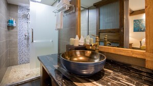 A bathroom with a large mirror, a bowl sink, and a shower area. - Li Jiang Tang Feng Yard No.1 (Lijiang)