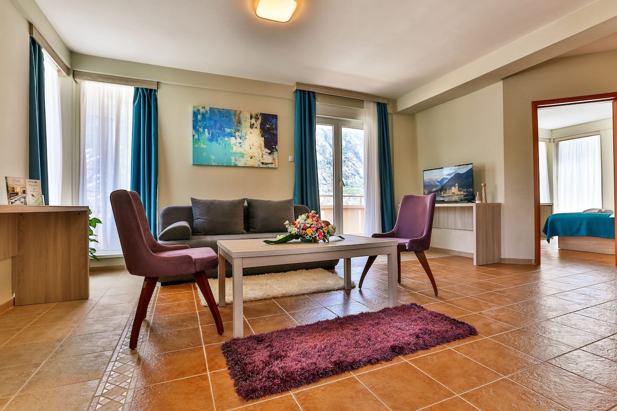 Un salon moderne comprenant un canapé, deux fauteuils, une table basse et un téléviseur.
