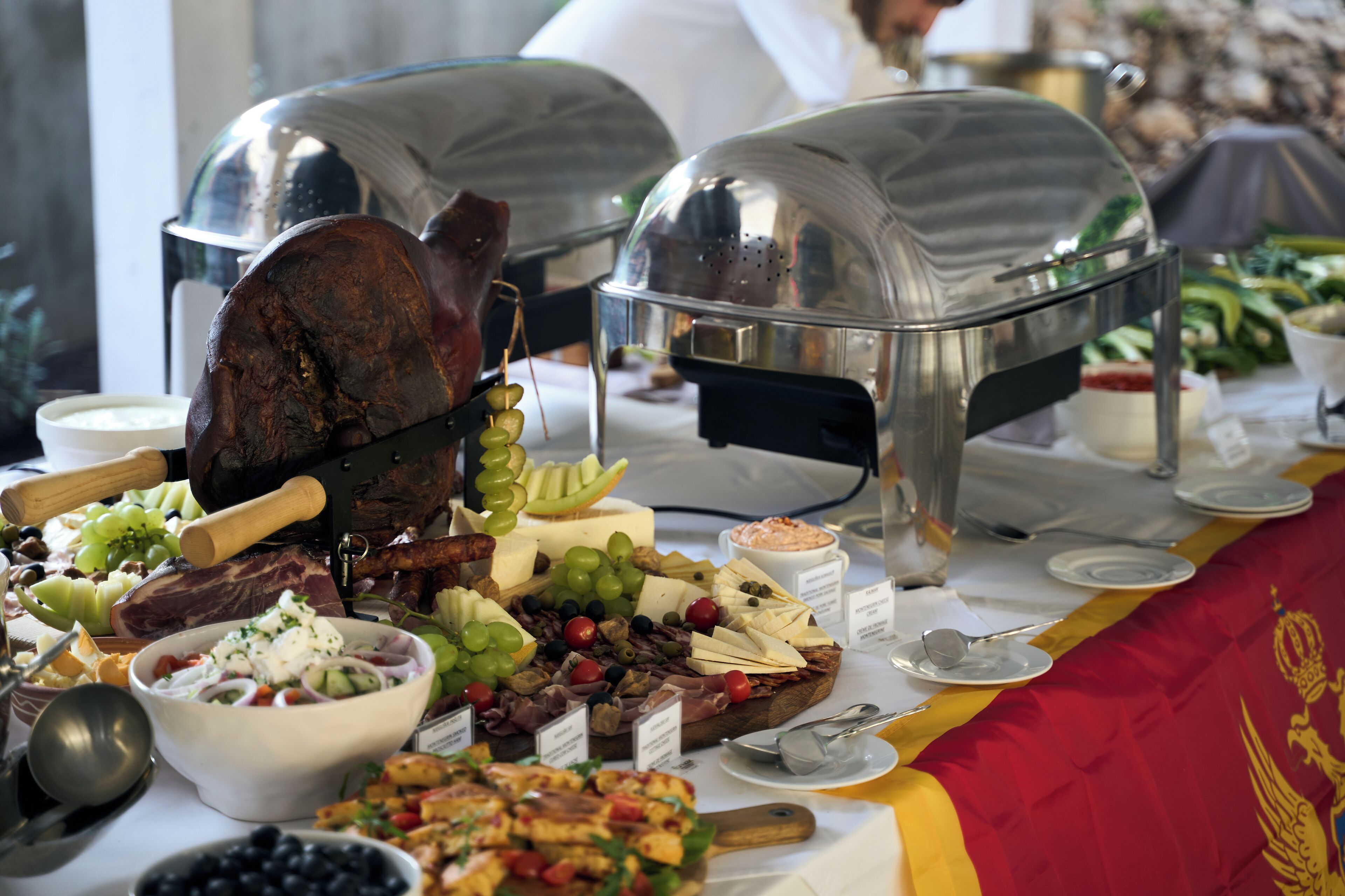 A buffet table with various food items and a large roasted meat centerpiece.
