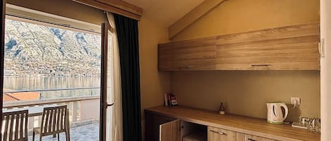Cocina compacta con lavavajillas integrado, armarios de madera y una pequeña encimera.
